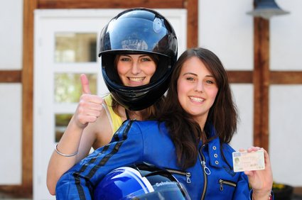 Zwei junge Frauen mit neuem Motorradhelm